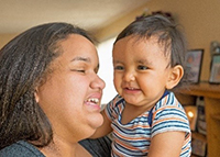 Woman holding her smiling baby