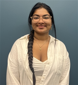 individual with a side braid wearing glasses smiling