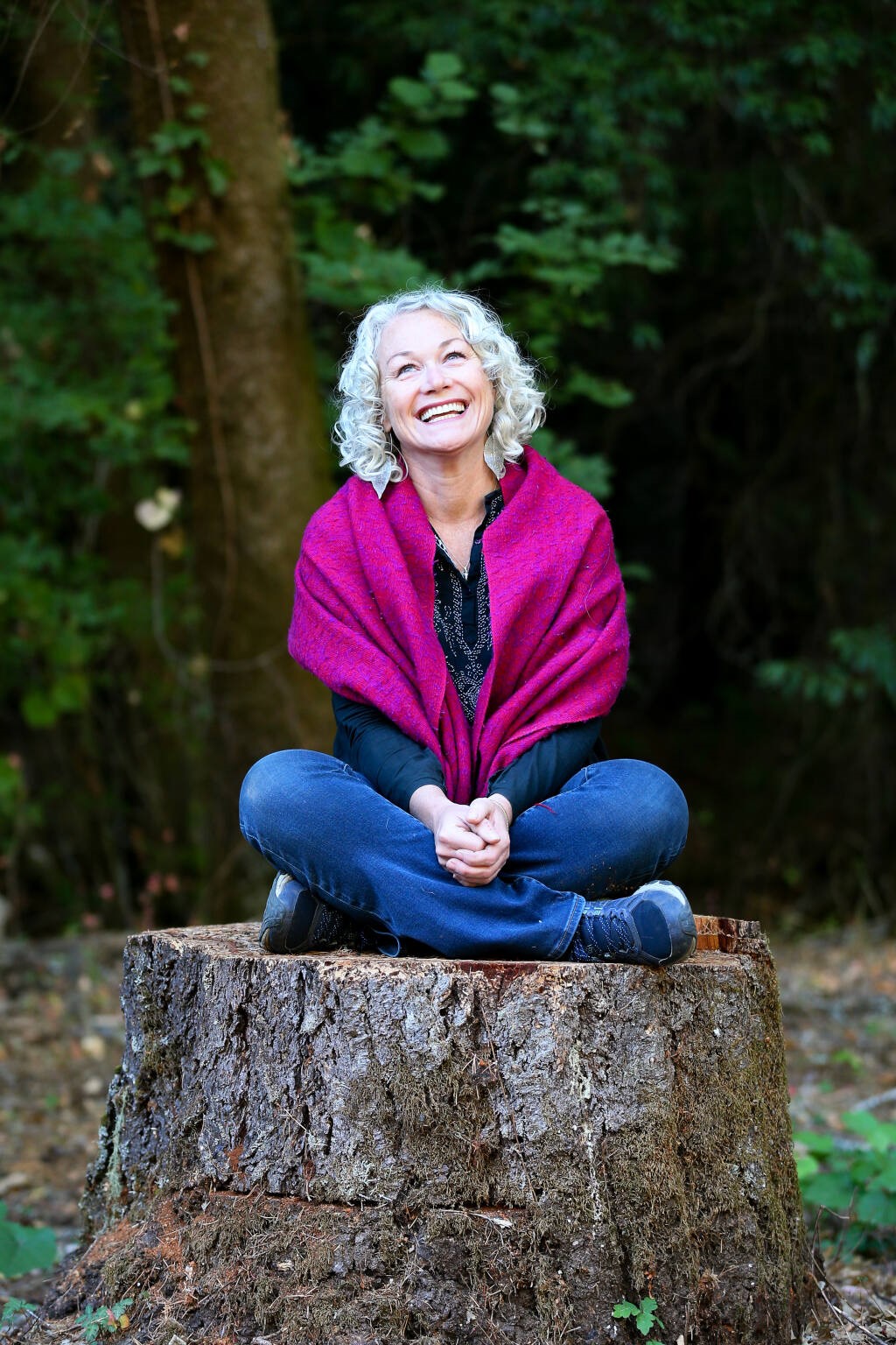 Nichole Warwick sitting on a tree log in nature