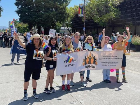 Commissioners holding their banner at Pride Parade