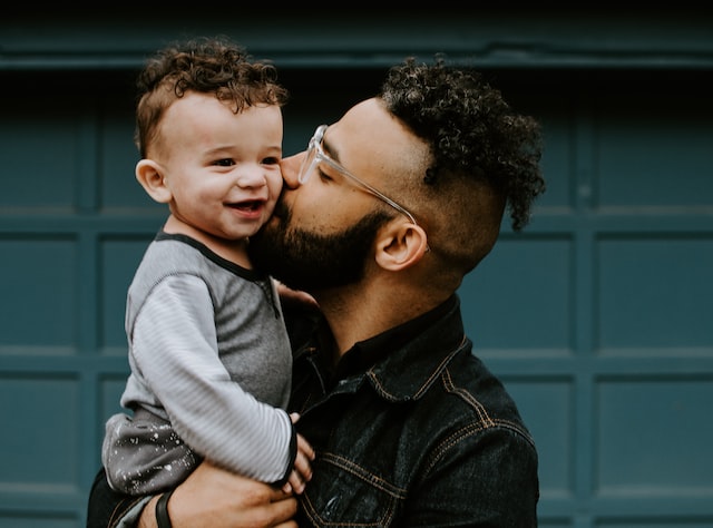 Dad kissing his son